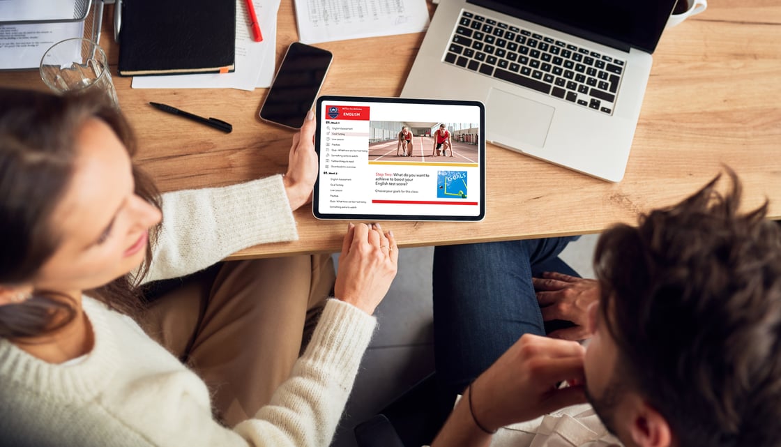 Two instructional designers looking at an eTablet with a course on the screen